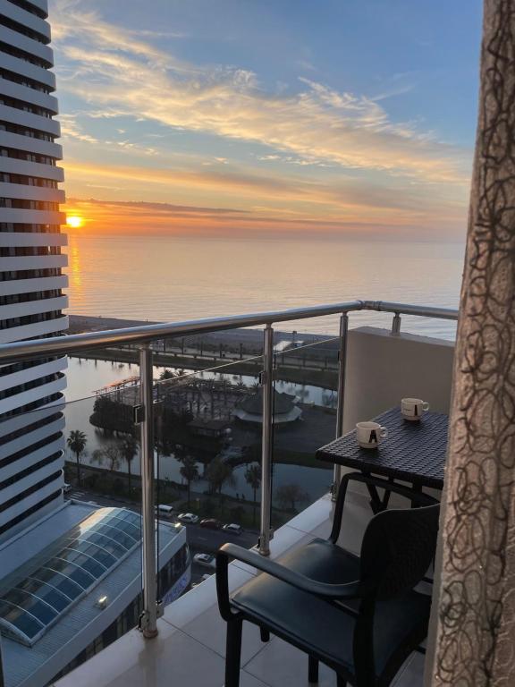 a balcony with a chair and a view of the ocean at Roini Apartment in Batumi