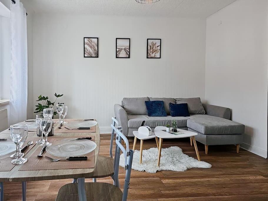 sala de estar con sofá, mesa y sillas en Appartement 2 chambres aux pieds des Vosges, en Abreschviller