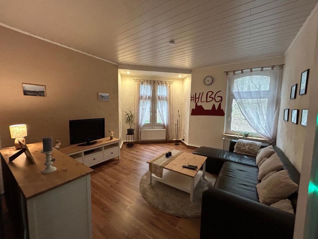 - un salon avec un canapé et une télévision dans l'établissement Ferienwohnung Obernahmer, à Hagen