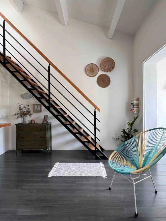 un salon avec un escalier et une chaise dans l'établissement Le Duplex, à Six-Fours-les-Plages