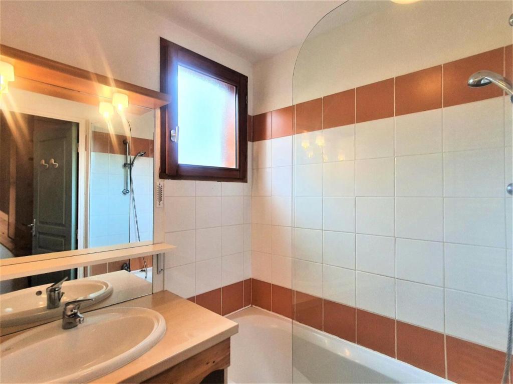 a bathroom with a sink and a mirror and a tub at Résidence Le Hameau Du Puy - Chalets pour 6 Personnes 874 in Le Dévoluy