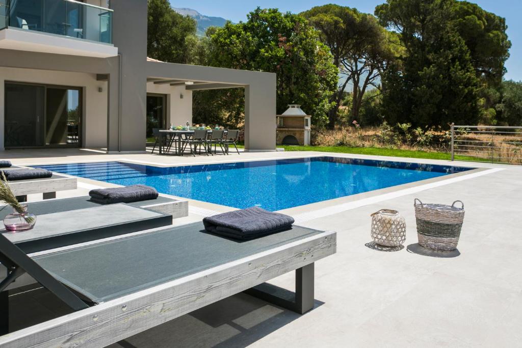 a swimming pool in the backyard of a house at Escape Villa Kefalonia in Lourdata