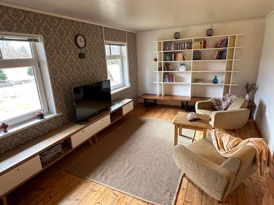 a living room with a flat screen tv and a couch at Your getaway home in Jausa küla in Hiiumaa