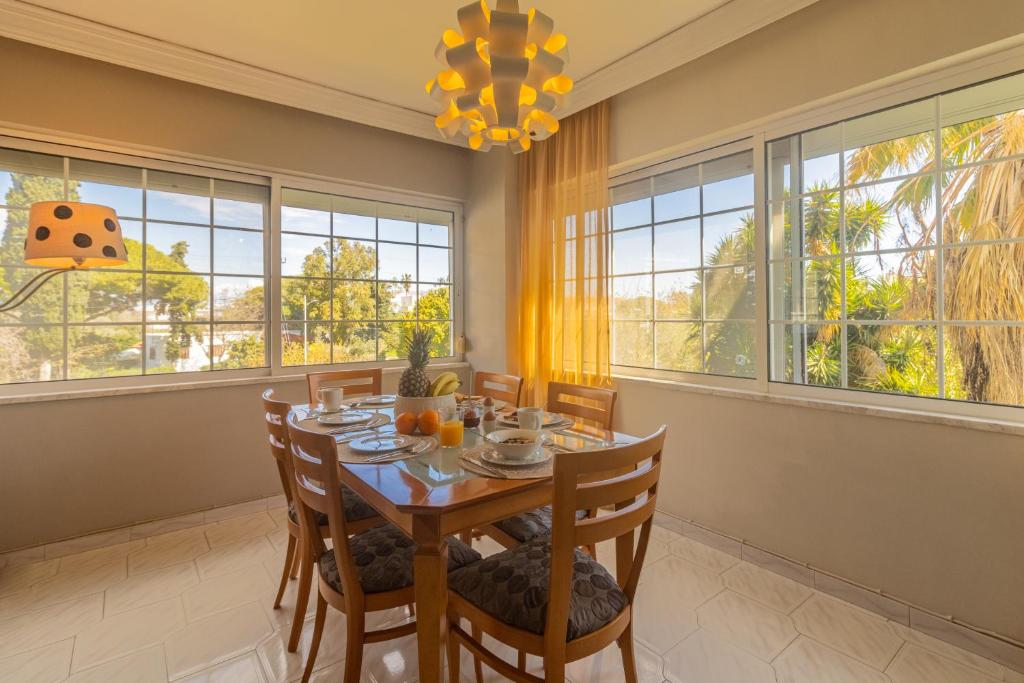 a dining room with a table and chairs and large windows at Erofili's Apartment ONLY 700 meters from the beach in Ialyssos