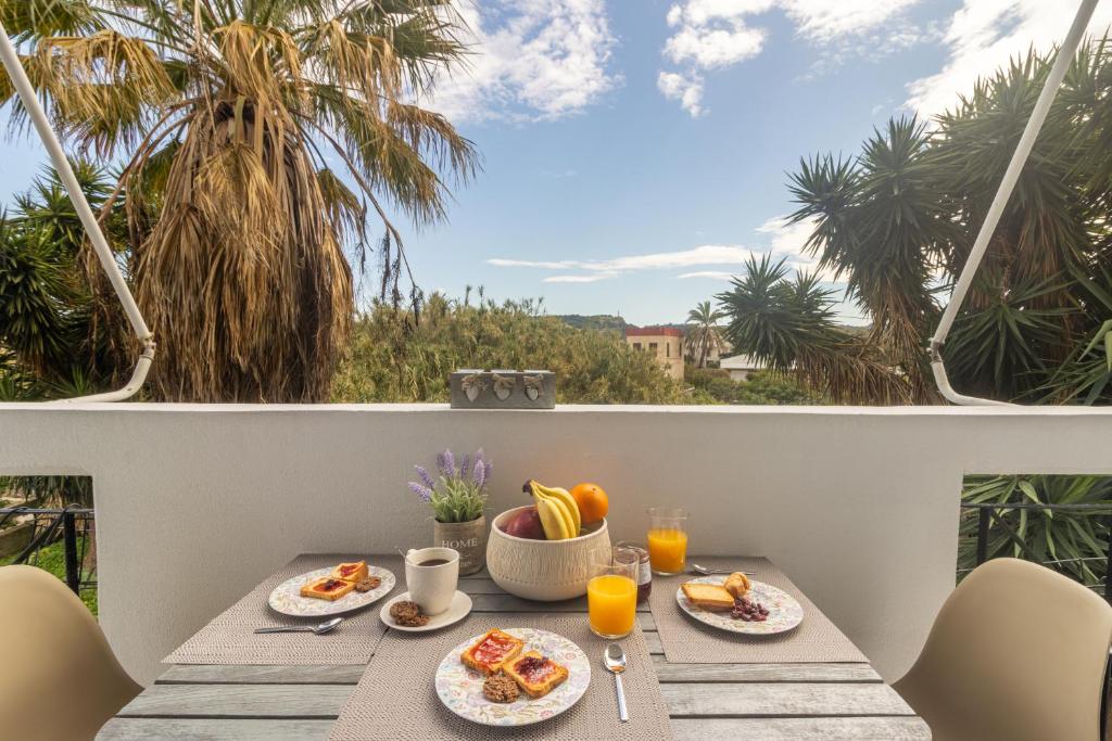 una mesa con desayuno en el balcón con vistas en Erofili's Apartment Rhodes 10 minutes from beach, en Ialisos