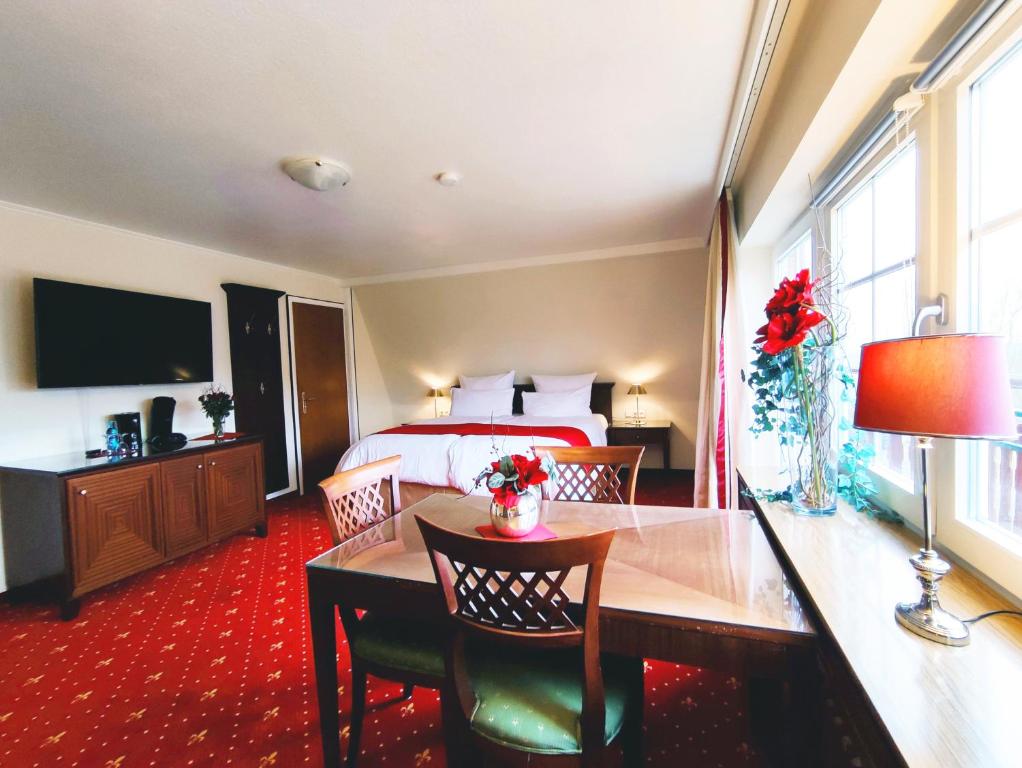 ein Hotelzimmer mit einem Bett, einem Tisch und Stühlen in der Unterkunft Gästehaus am Herrendeich in Nordstrand