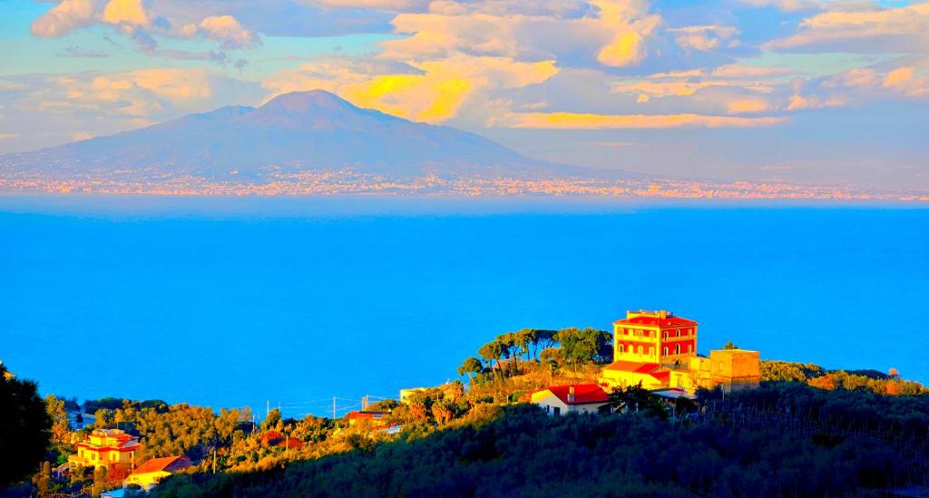 ein Bild eines Gebäudes auf einem Hügel mit einem Berg in der Unterkunft Gli Occhi Del Mare in Sorrent