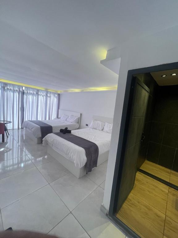 1 dormitorio con 2 camas y ventana grande en The Lodge Ajloun en Ajloun