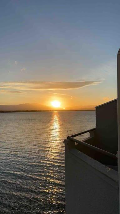 un coucher de soleil sur une étendue d'eau avec un bateau dans l'établissement Appartement T2 dans jolie résidence avec piscine, au Barcarès