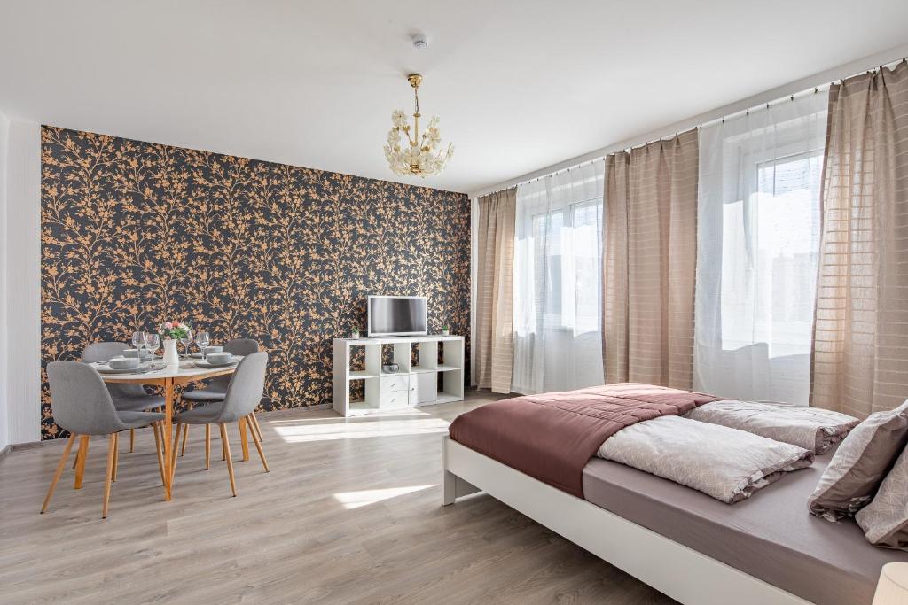 1 dormitorio con 1 cama y 1 mesa con sillas en Lizo2 3 csillagos apartman modern stílusban en Székesfehérvár