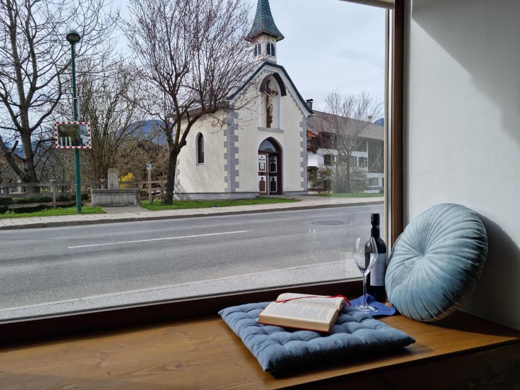 ein Fenster mit einem Buch und einer Flasche Wein in der Unterkunft Kapellenblick in Bad Häring