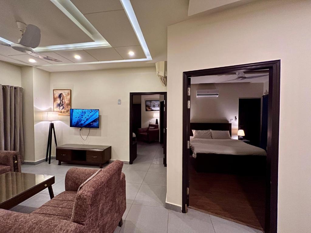 um quarto de hotel com uma cama e uma sala de estar em Serenity Corner em Islamabad