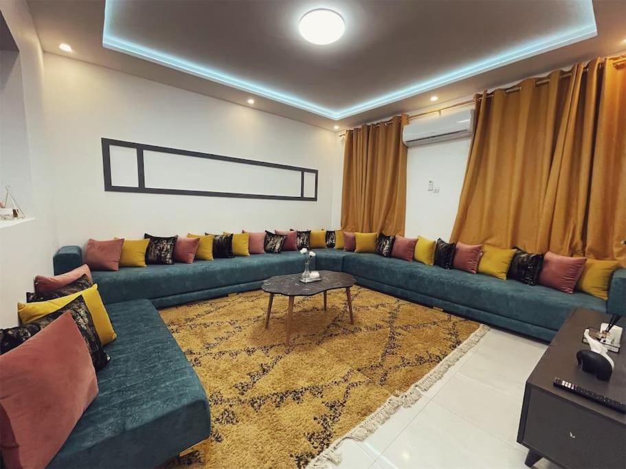 a living room with a blue couch and a table at Appartement de luxe avec un toit terrasse in Nouakchott