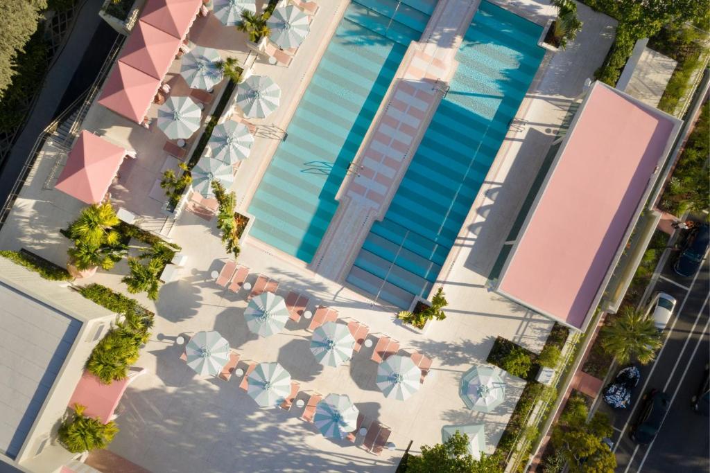 an overhead view of a swimming pool with chairs and umbrellas at The Goodtime Hotel, Miami Beach a Tribute Portfolio Hotel in Miami Beach