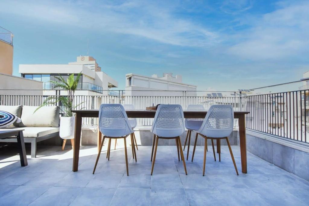 a patio with a table and chairs on a balcony at Marine Pearl by HolyGuest in Tel Aviv