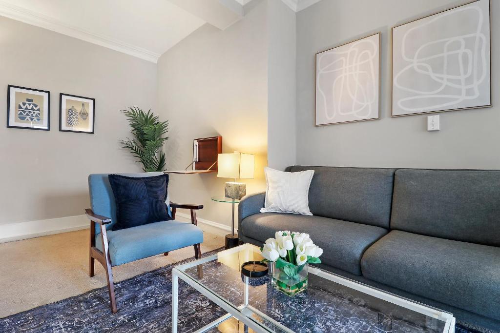 ein Wohnzimmer mit einem Sofa und einem Stuhl in der Unterkunft Elegant 1BR Hyde Park Apartment - Windermere 310 in Chicago