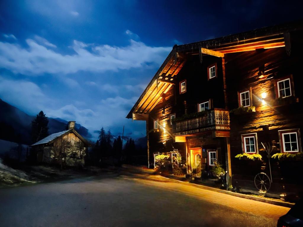 a wooden house with lights on the side of a street at Arlerhof in Untertauern