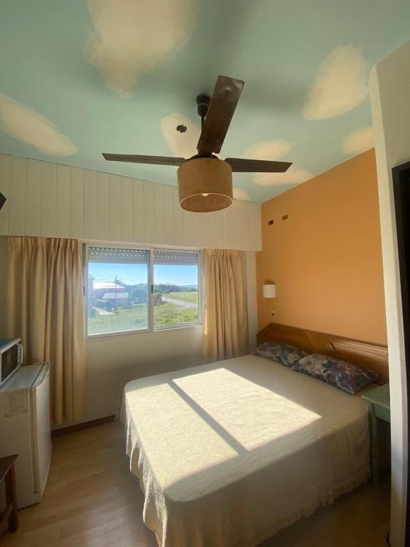 1 dormitorio con 1 cama y ventilador de techo en Habitación frente al mar en Mar del Plata