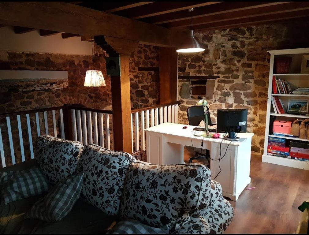 a living room with a couch and a desk at Casa restaurada en pequeño pueblo de montaña in Pujayo