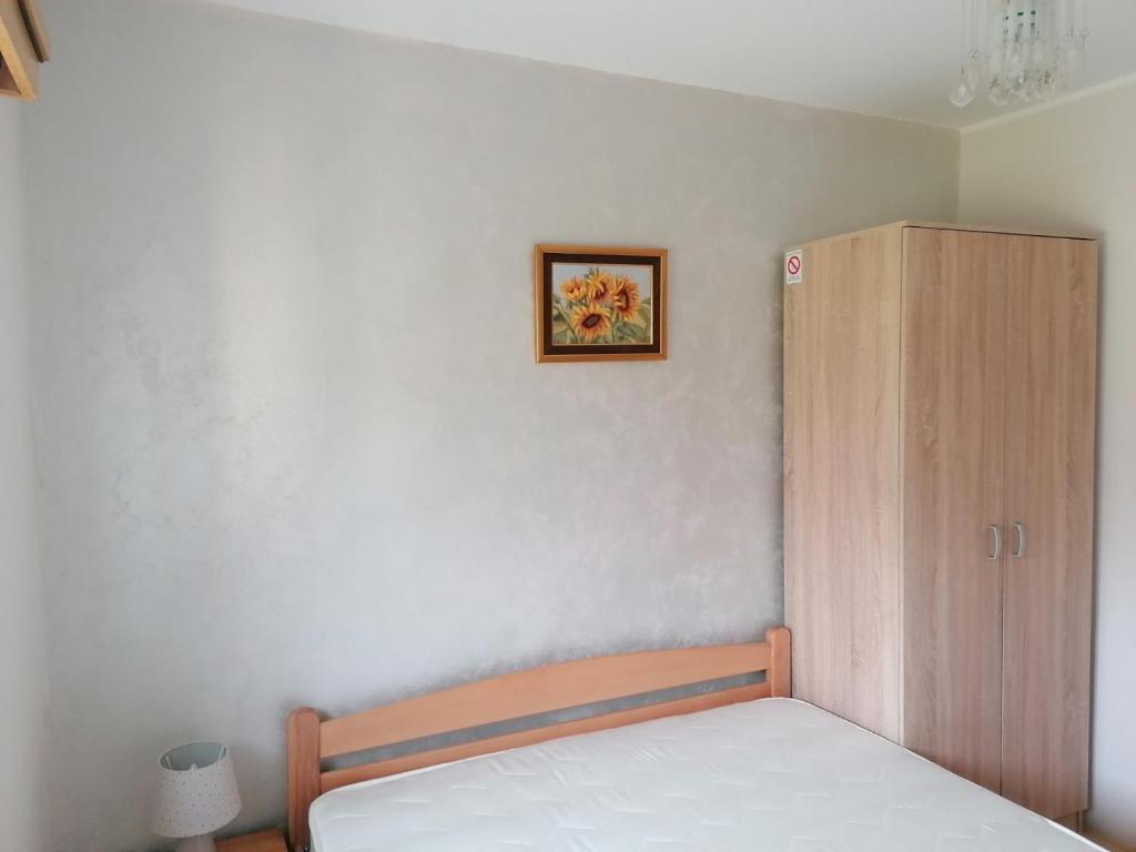 a bedroom with a bed and a wooden cabinet at Vikendica Budžak 51 - Apatin in Apatin