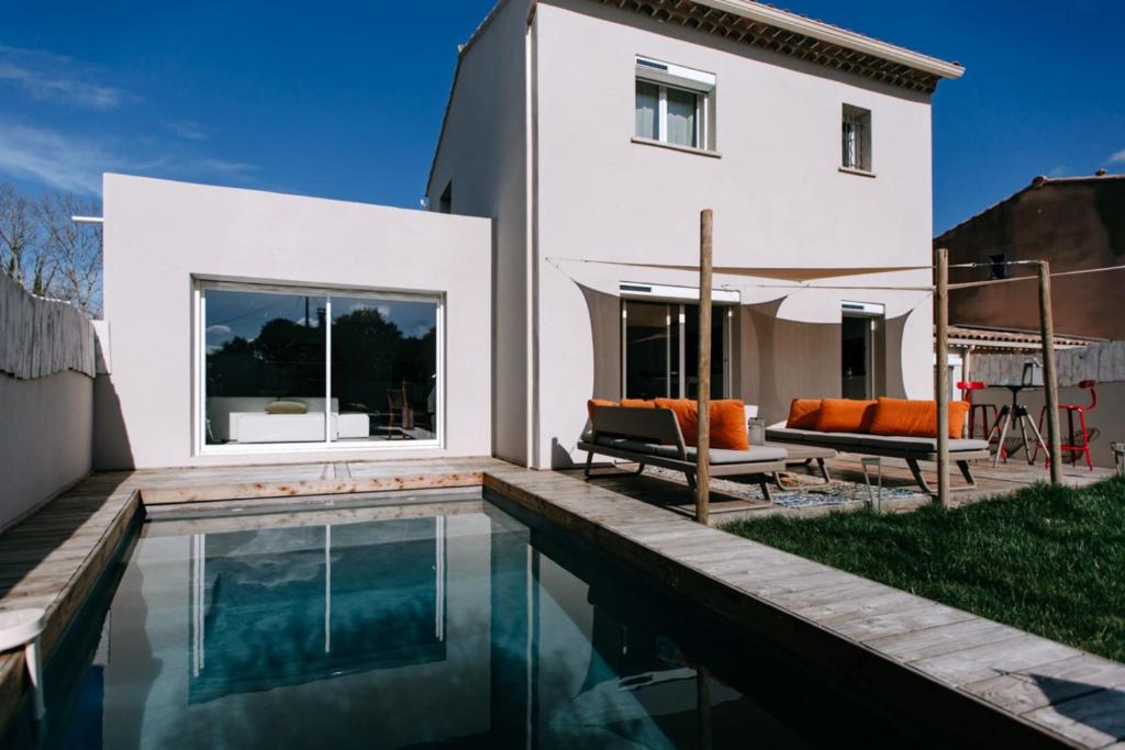 une maison avec une piscine en face d'une maison dans l'établissement Bright Contemporary House - Private Pool, à LʼIsle-sur-la-Sorgue