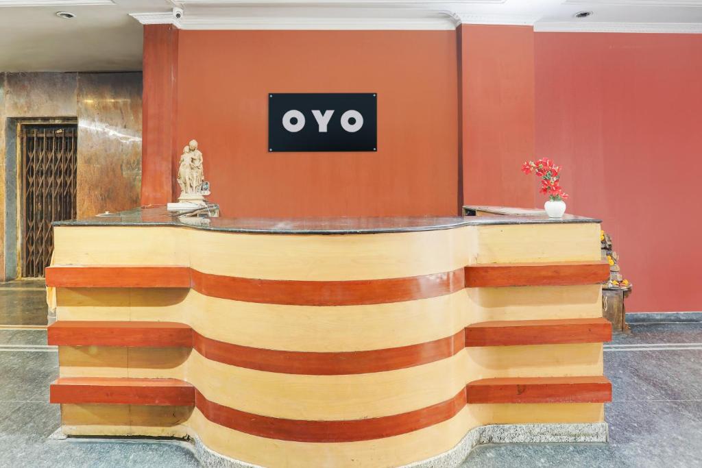 a reception desk in a lobby with a sign on the wall at SPOT ON Hotel Rk Residency Near MGBS Bus station in Hyderabad