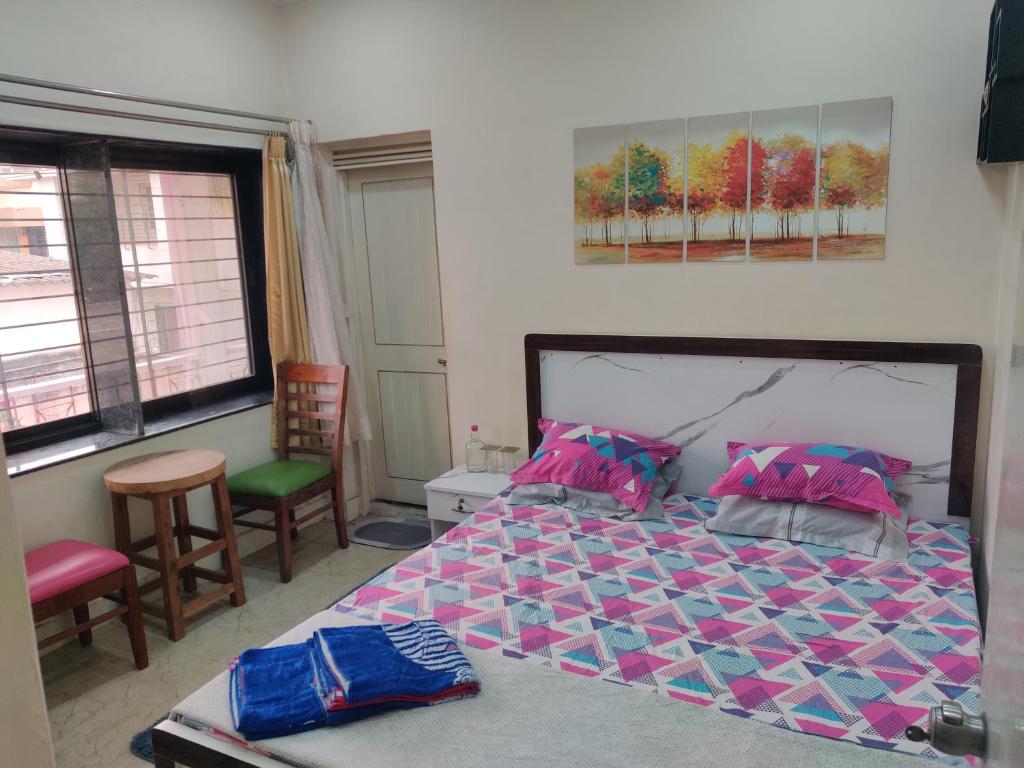 a bedroom with a bed and two chairs and a window at Nest in Nashik