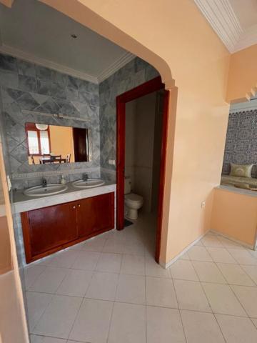 uma casa de banho com um lavatório, um WC e um espelho. em Mehdia Ville em Plage de Mehdia