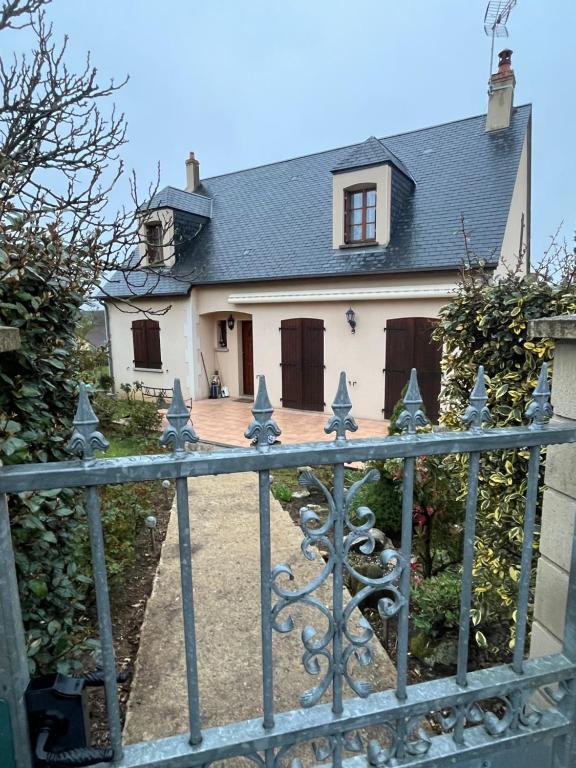une maison blanche avec une porte en face dans l'établissement À 5 minutes à pieds du château, 2 belles et spacieuses chambres, SDB, WC et un garage privé à 25 minutes circuit 24h, à Le Grand-Lucé