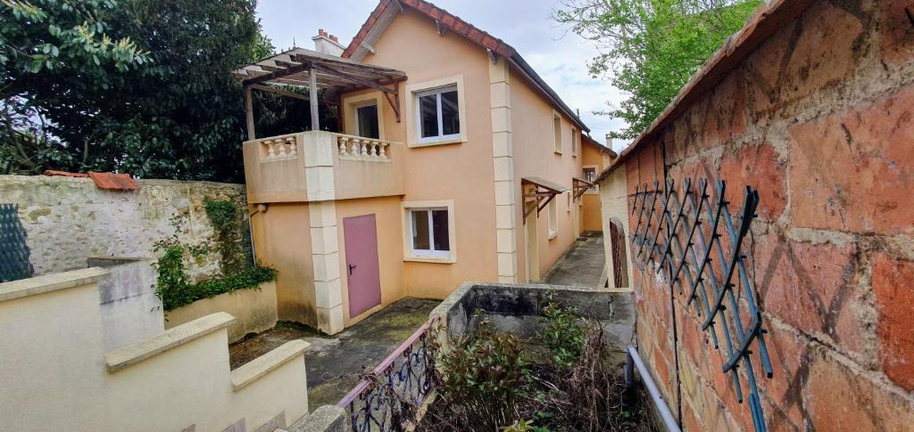 a house with a balcony on the side of a wall at COQUELICOT - Spacieuse maison 172m2 - 4 chambres - Parking Privé & Wifi Gratuit in Brunoy