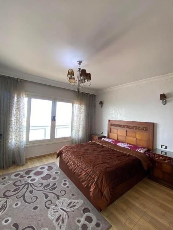 a bedroom with a large bed and a large window at gleem alexandria in Alexandria