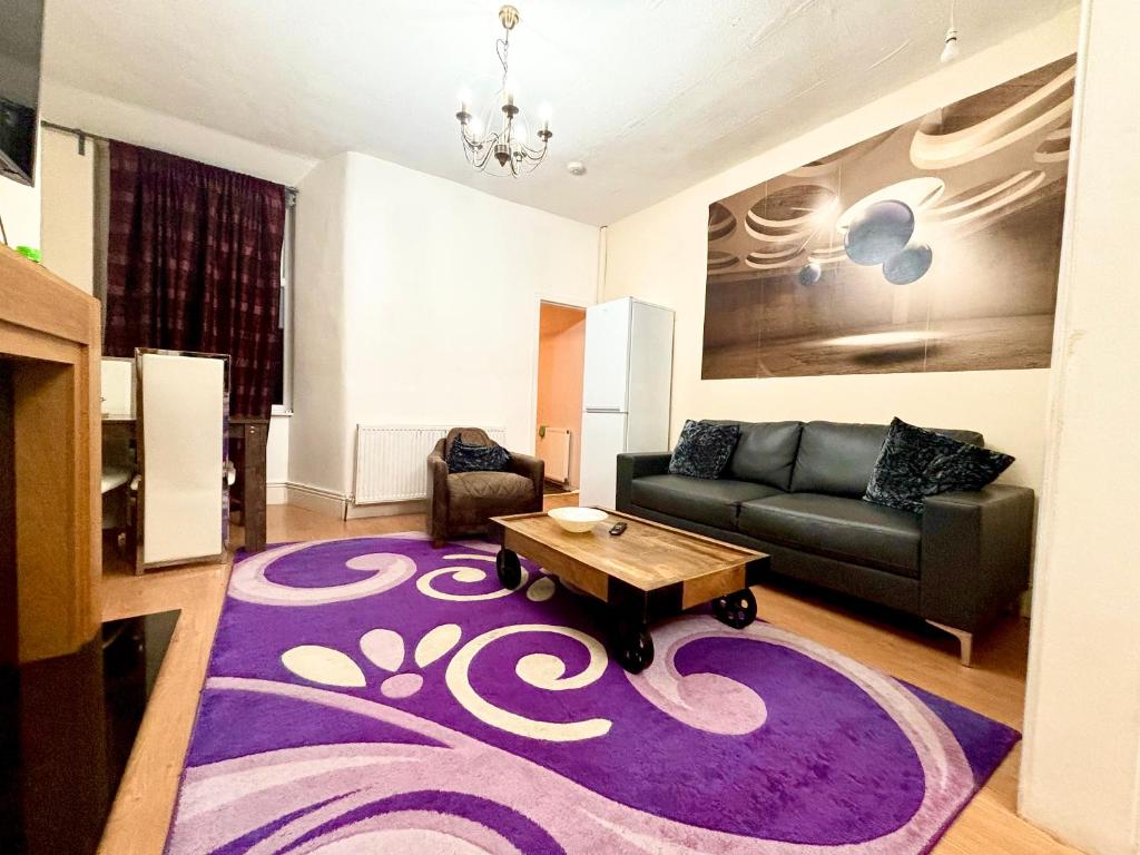 ein Wohnzimmer mit einem Sofa und einem lila Teppich in der Unterkunft Olive House in Manchester