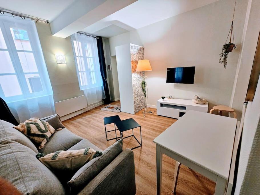 een woonkamer met een bank en een tafel bij Oasis Parfumée 4 couchages in Grasse