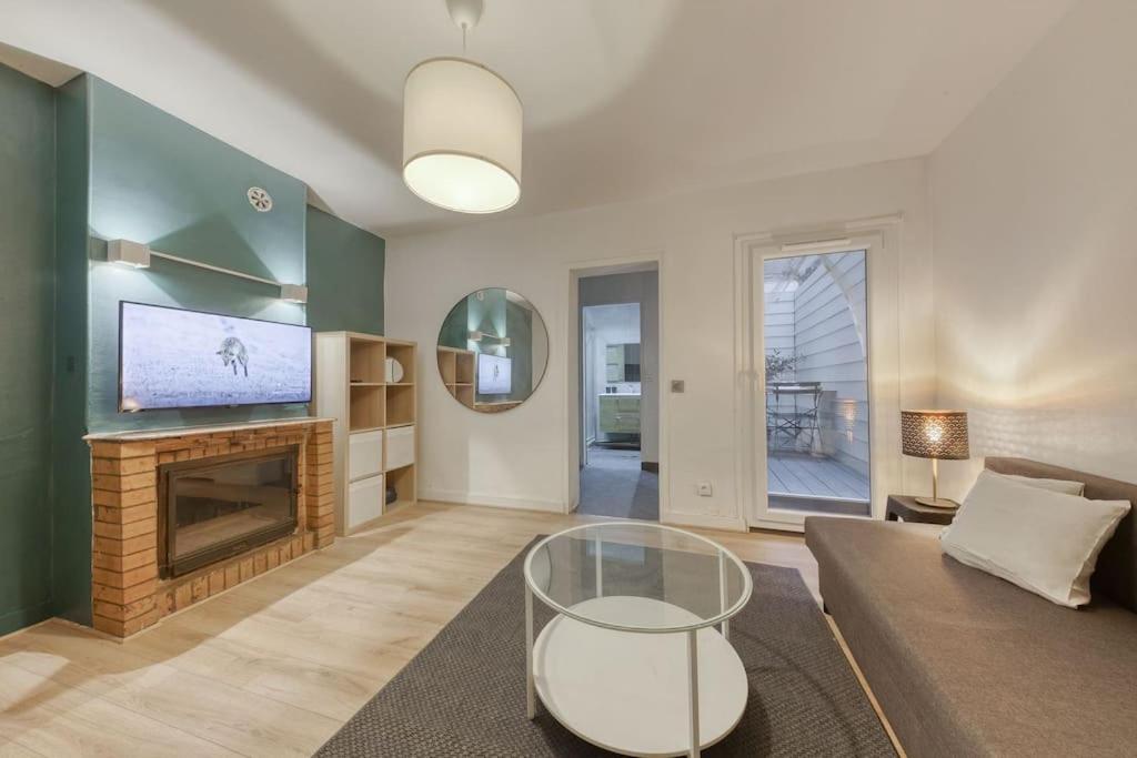 un salon avec un canapé et une cheminée dans l'établissement *Le Chic* Proche Paris JO 2024, à Clichy