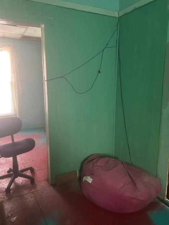 a green room with a chair and a tent at Leah Bungalow in Lincoln