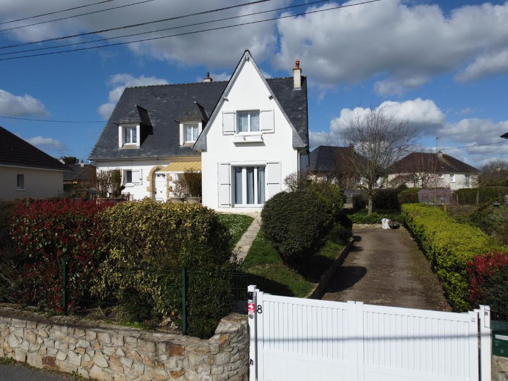 a white house with a white fence in front of it at Appartement et Maison Espace Mayenne in Laval
