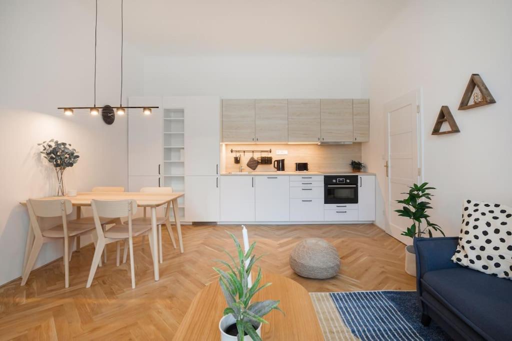 eine Küche und ein Wohnzimmer mit einem Tisch und Stühlen in der Unterkunft Beautiful cozy apartment for 2 people in Prag
