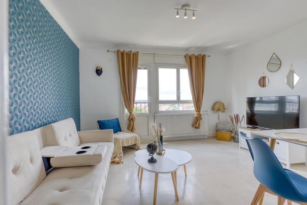 un salon avec un canapé et une table dans l'établissement *Le moderne* Paris / la Défense parking / JO 2024, à Houilles