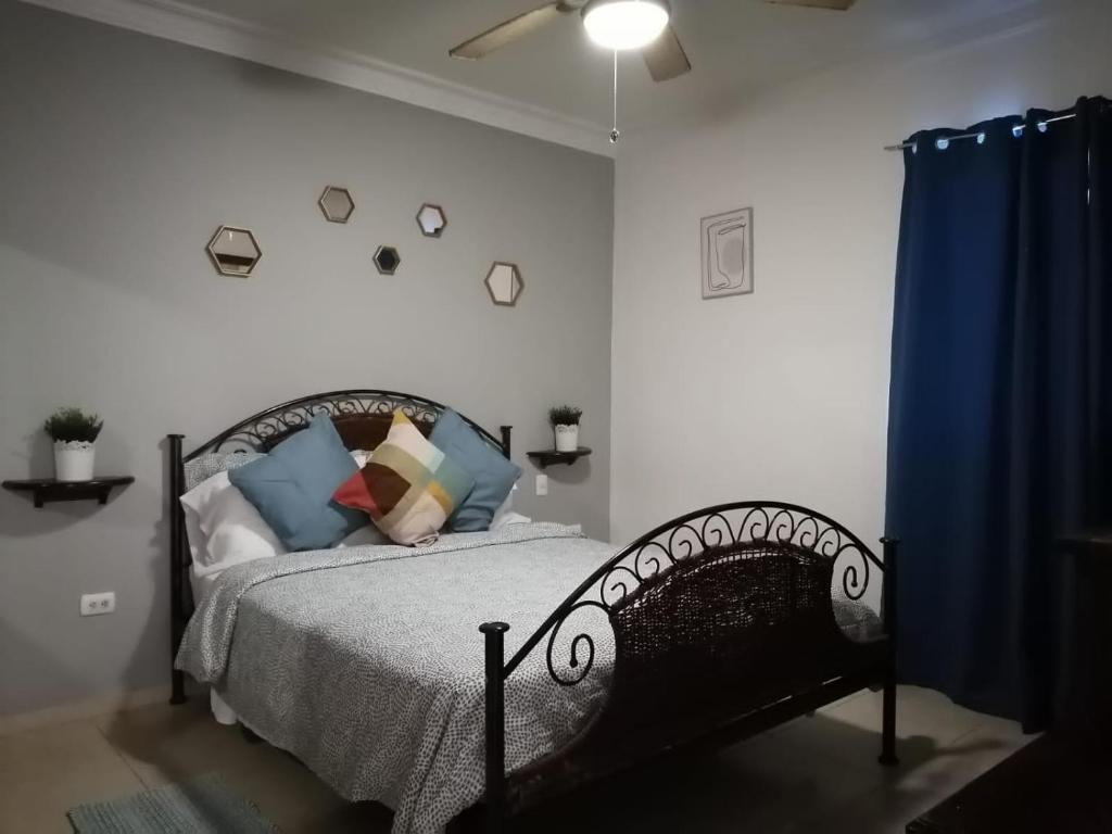 a bedroom with a bed and a blue curtain at to little away from El conde ,museums, parks in the colonia zone in Santo Domingo