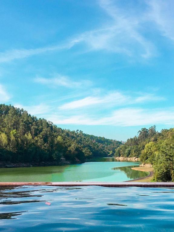 a large body of water with trees in the background at Quinta da Azenha in Amarante