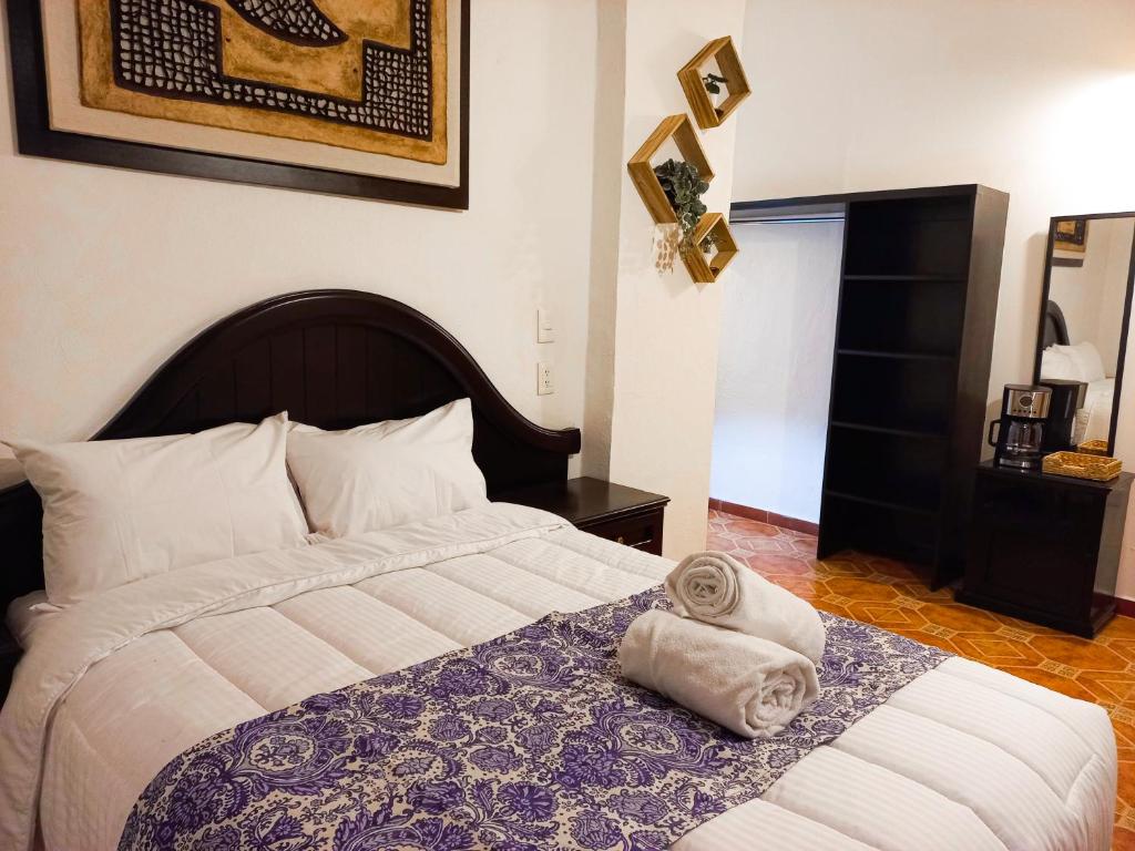 a bedroom with a bed with towels on it at CASONA ALBARELO in Puebla