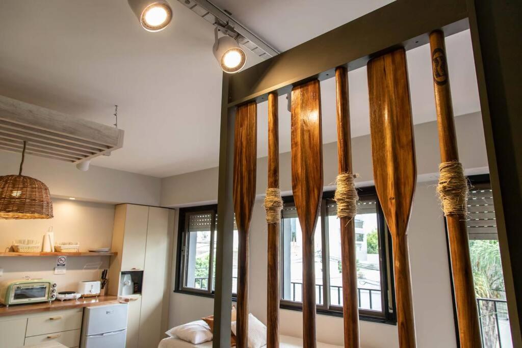 a room with windows with curtains and a kitchen at Departamento del río Paraná de las Palmas in Campana