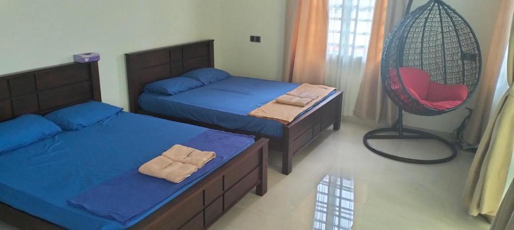 1 Schlafzimmer mit 2 Betten und einem roten Stuhl in der Unterkunft Villa Senitaman Organik in Seremban