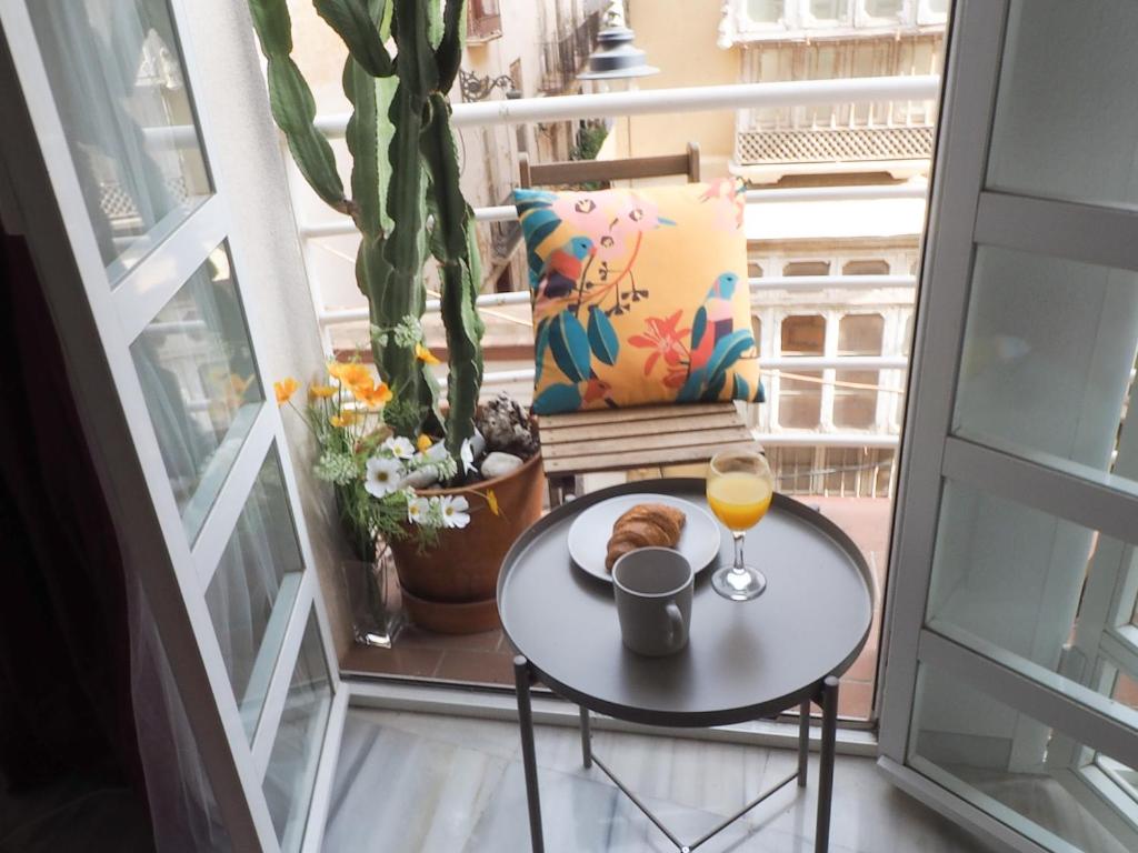 a table with a plate of food and a glass of orange juice at Ollerías 35 by Nagoa Homes in Málaga