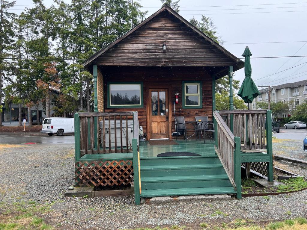 a small house with a green porch and a porch at Bridge Tender Shack with hot tub on deck in La Conner