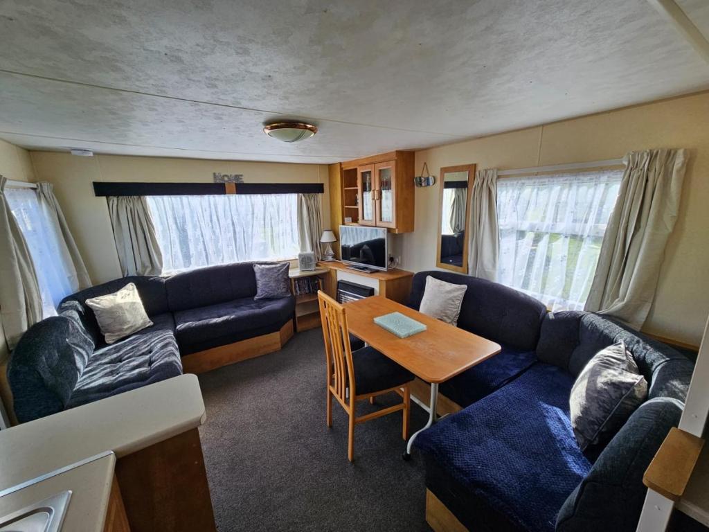 a living room with a couch and a table at Caravan holiday let 2 bedroom happy days SOUTH chapel saint Leonards 05 in Chapel Saint Leonards