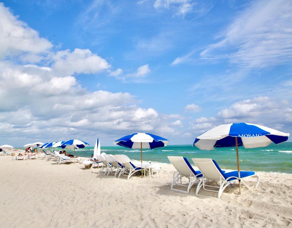 - un groupe de chaises longues et de parasols sur une plage dans l'établissement Miami Beach Stay 3 min to Ocean, à Miami Beach