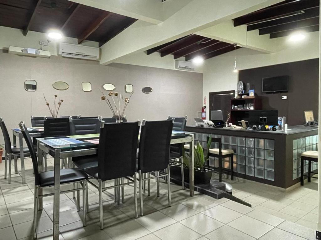 ein Restaurant mit einem Tisch, Stühlen und einer Theke in der Unterkunft HOSTAL IBRAIS in Panama-Stadt