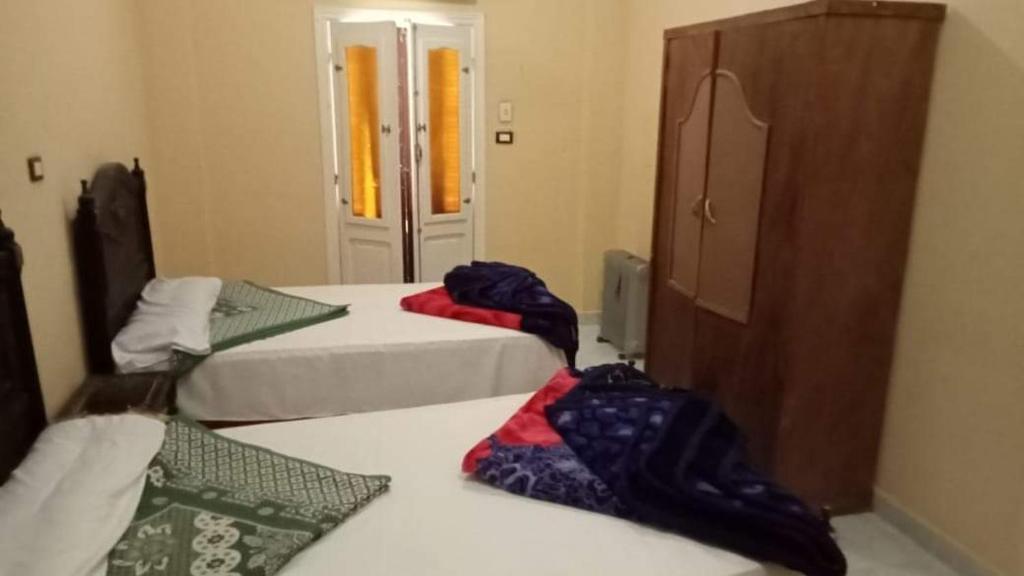una camera con due letti e un armadio con porta di سيوة تورز للسياحة العلاجية a Siwa