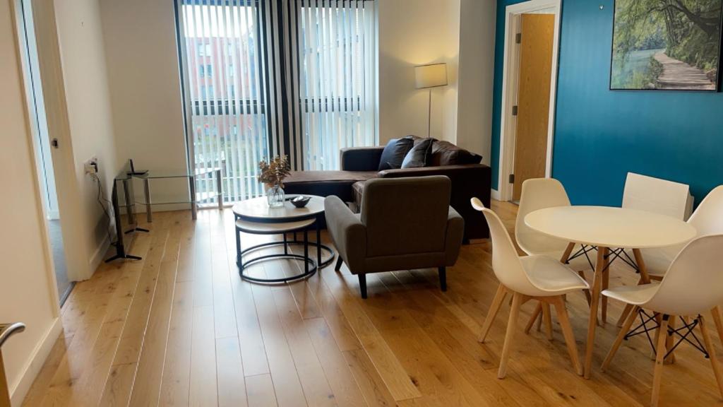 uma sala de estar com um sofá, uma mesa e cadeiras em 310 Arden Gate em Birmingham